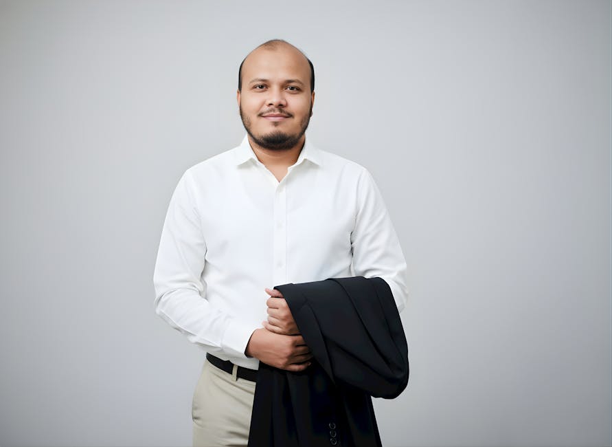 Confident man wearing white shirt holding a suit jacket, ready in professional attire.